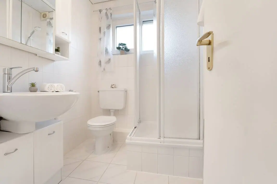 Helles Badezimmer mit Dusche, Waschbecken und WC