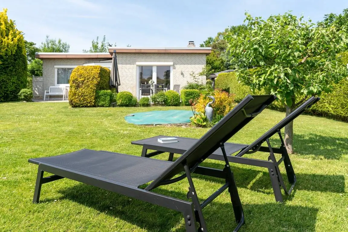 Garten von Snieder’s Hoeg mit Rasen, Sonnenliegen und Blick auf das Haus