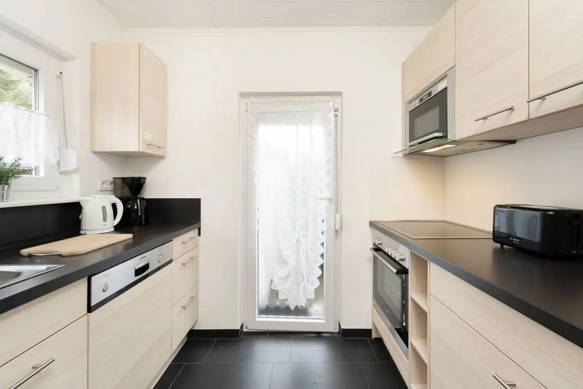 Helle separate Küche mit Küchenzeilen, Fenster und Gartentür